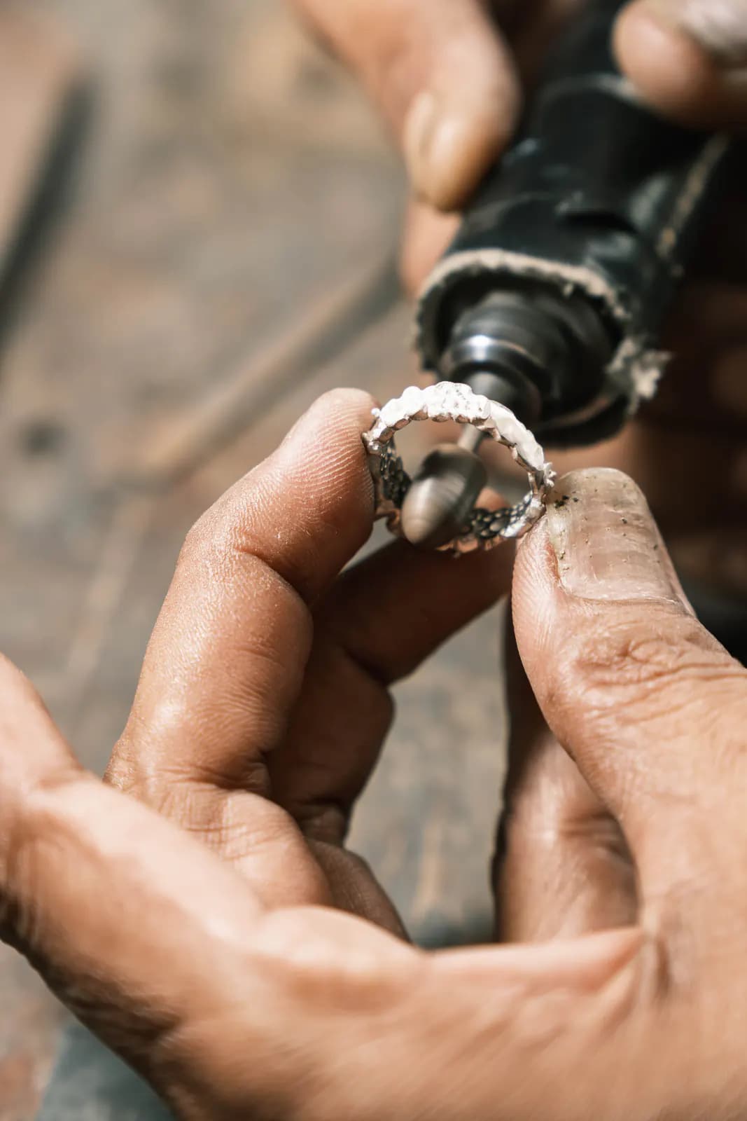 Hands holding a ring against a rotary polishing tool