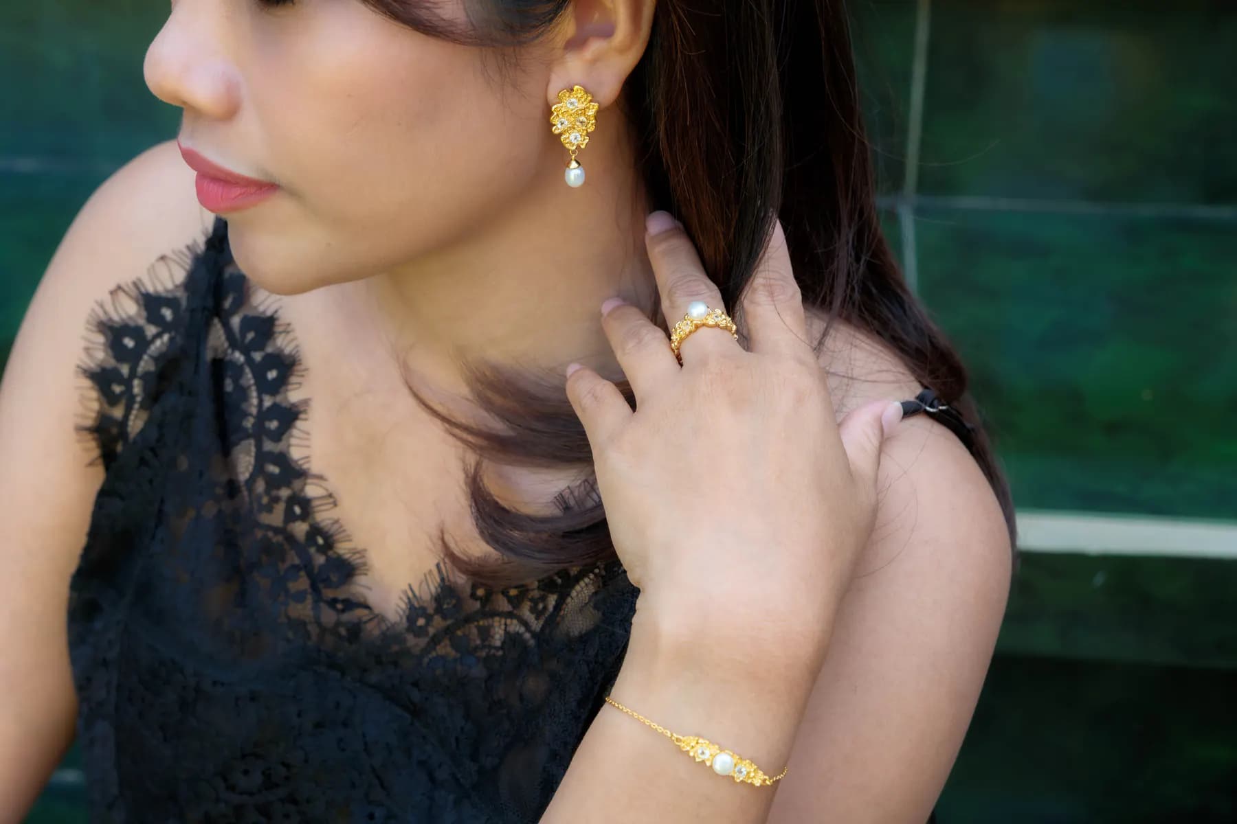 Woman in black lace wearing MEDINI pearl drop earrings, ring and bracelet